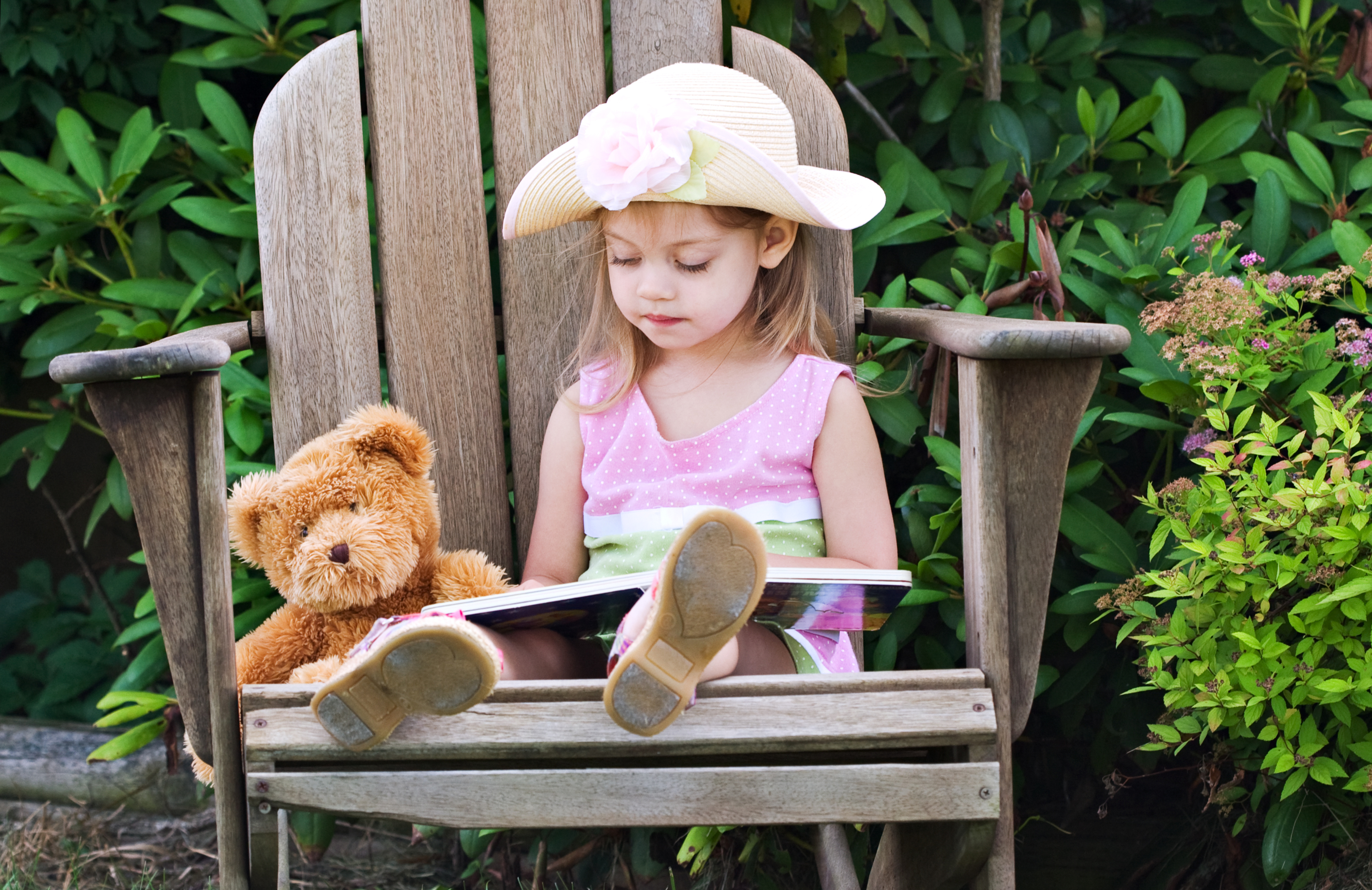 girl reading with teddy bear